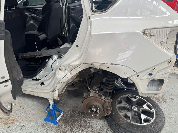 Subaru with rear quarter panel stripped after collision
