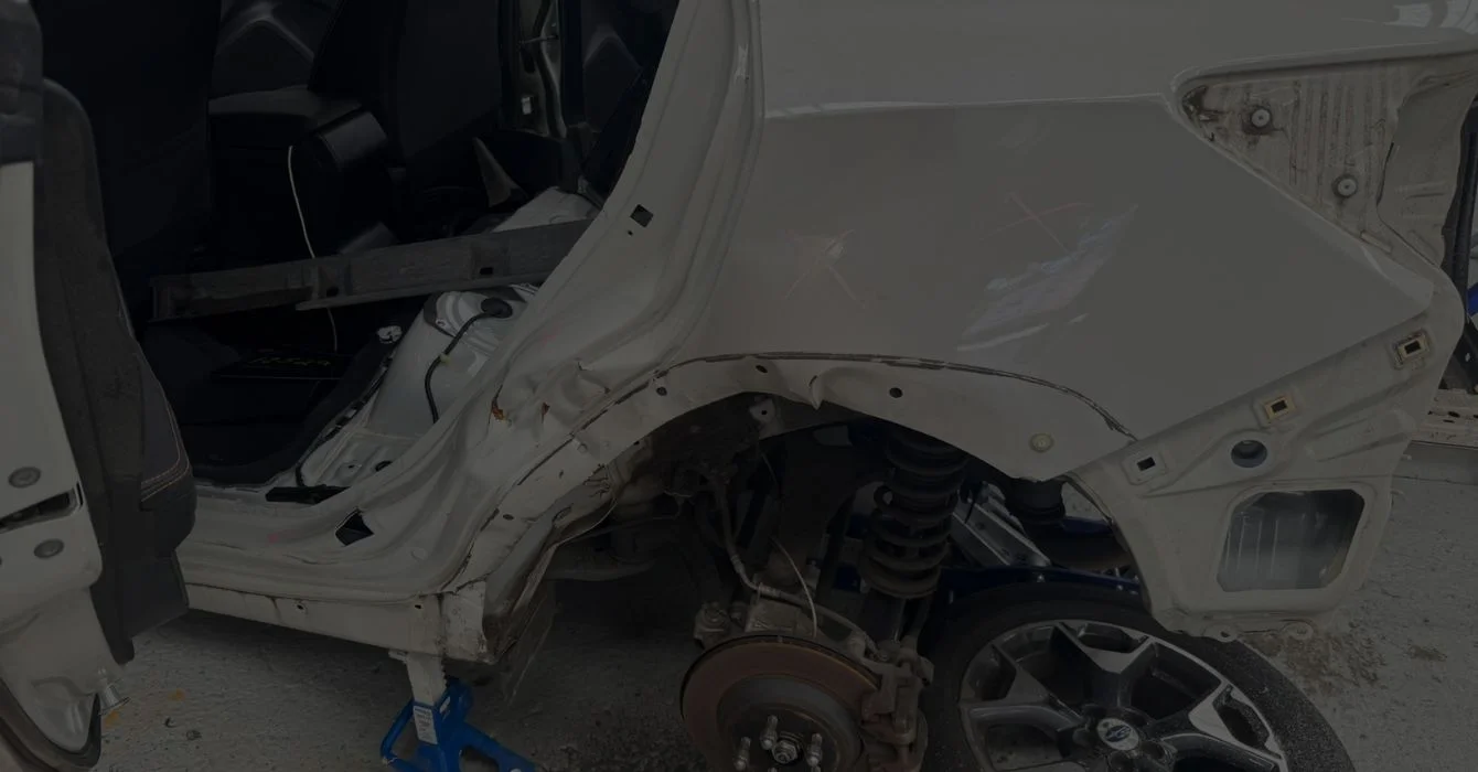 A dismantled vehicle with X marks highlighting damaged structural areas, illustrating detailed inspection during structural evaluation.