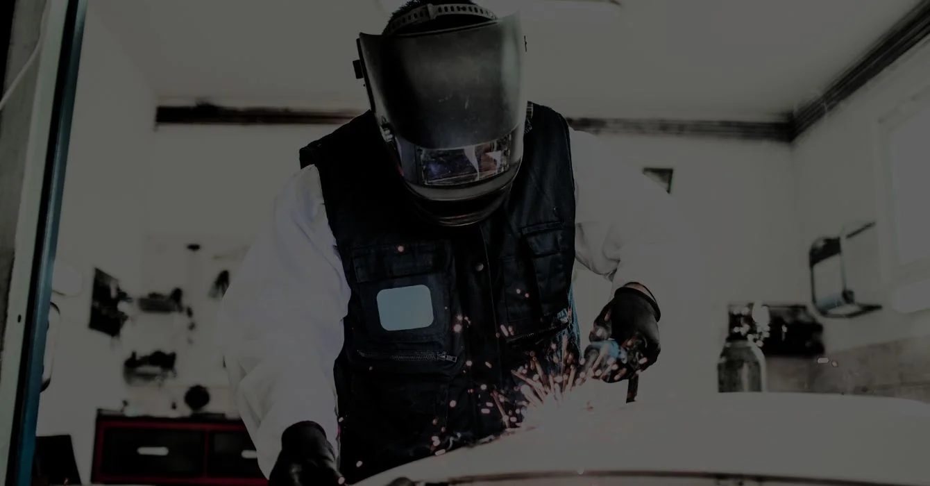 A qualified technician welding a vehicle frame, showcasing expertise in structural automotive repairs.