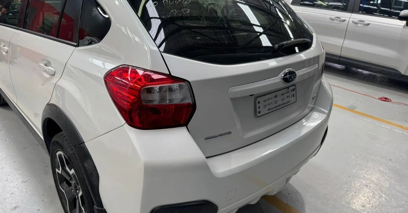 A fully repaired car parked in a well-lit workshop, highlighting restored structure and functionality after professional smash repairs.