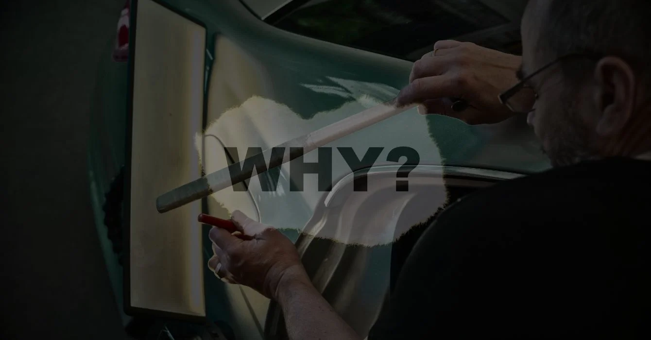 A smash repair expert using a light to inspect a vehicle panel, illustrating the precision and care behind our repair services.